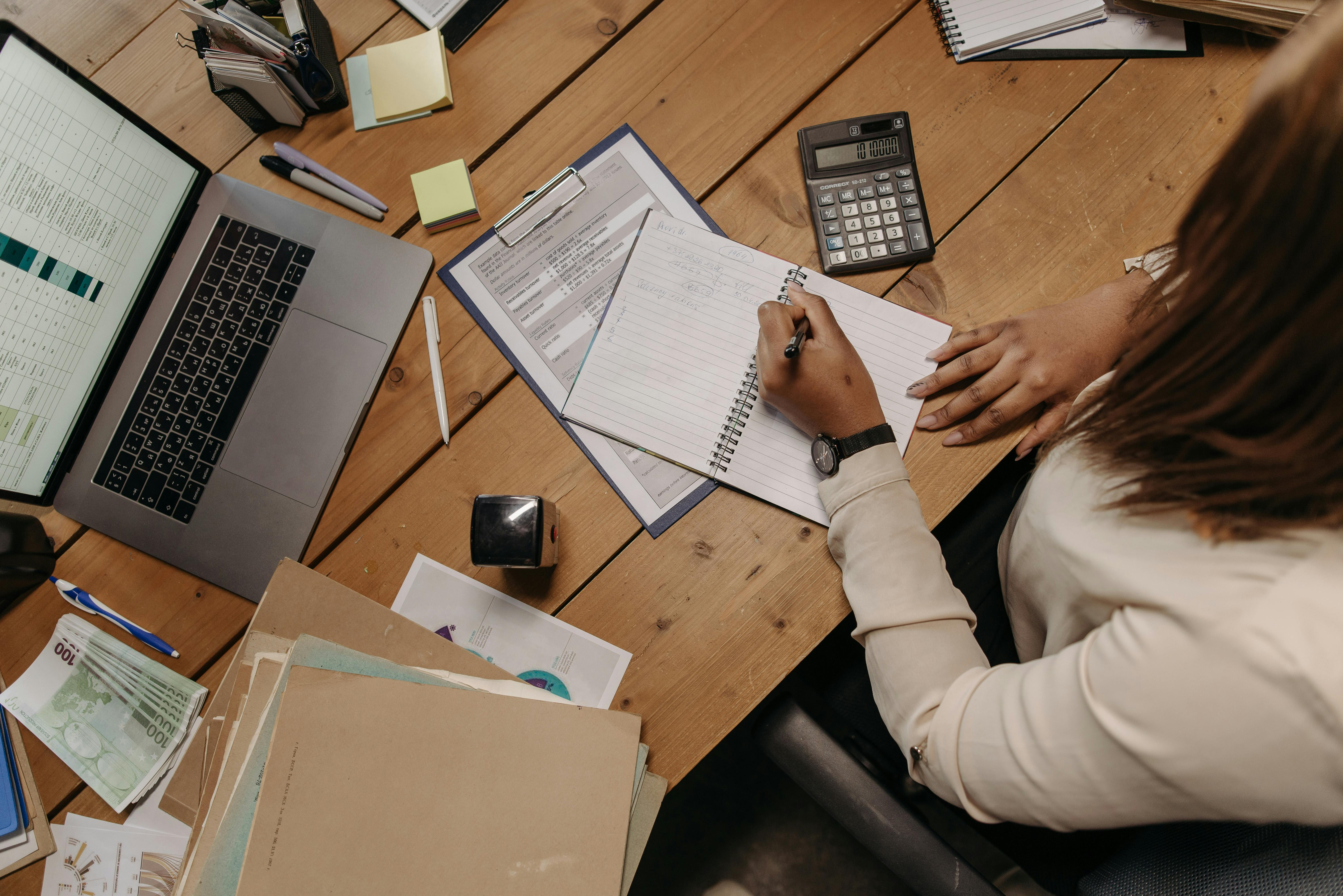 A desk with a laptop, calculator, and billing materials, suitable for explaining top-ups and billing management