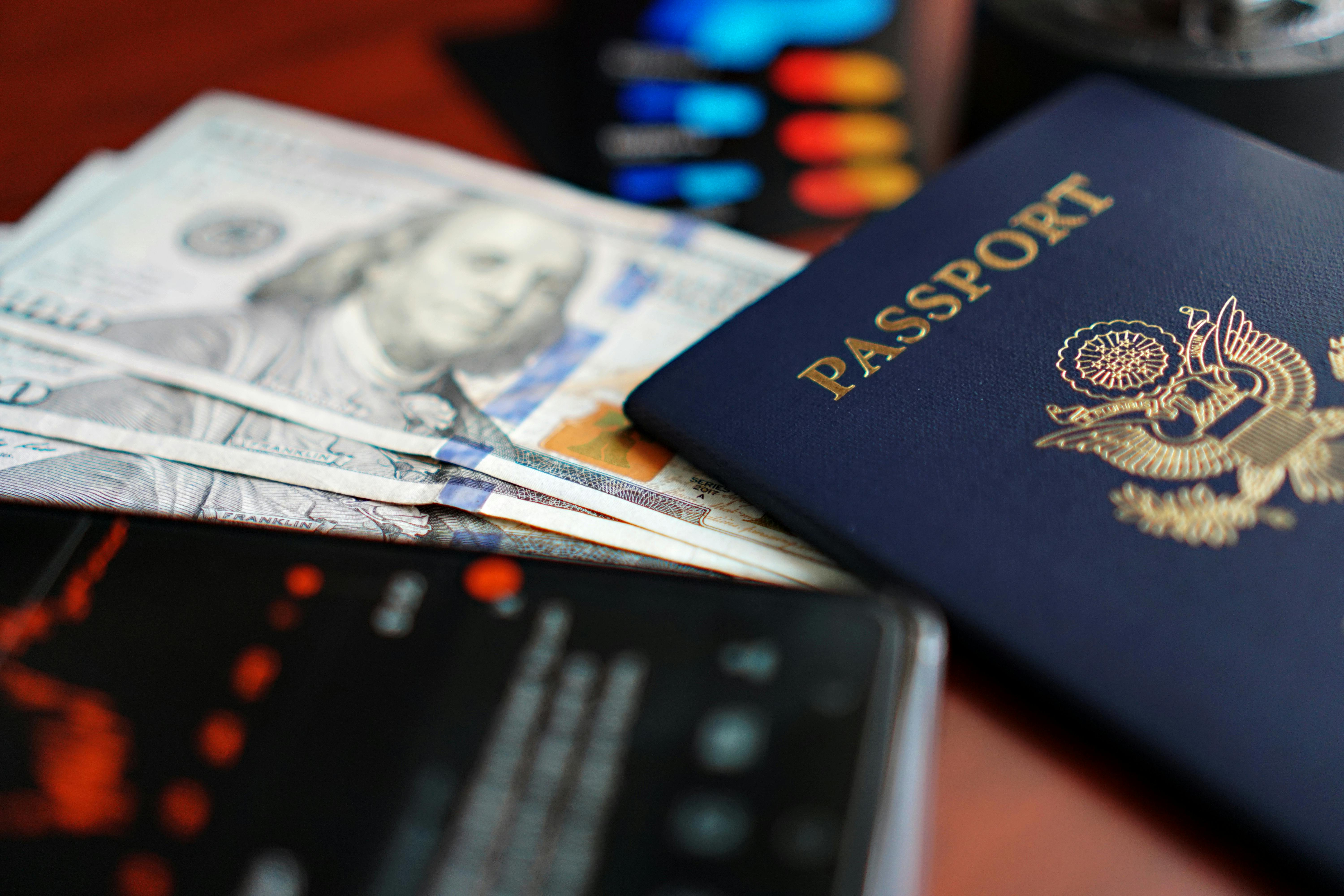 Passport, cash, and mobile financial applications representing overseas living, foreign currency assets, and cross-border financial usage