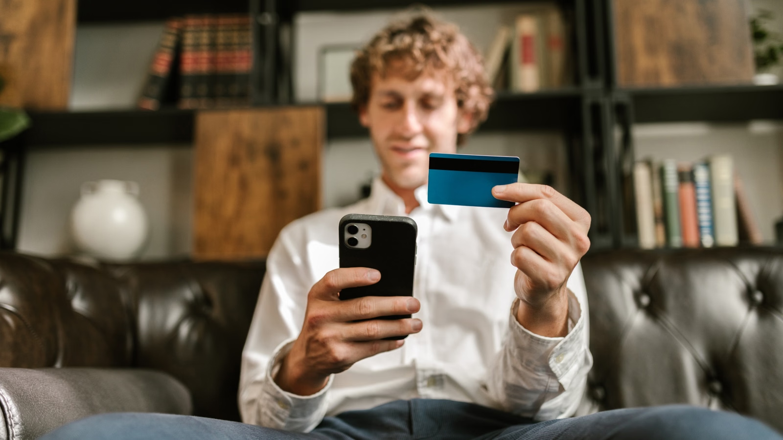 Person holding a phone and card for mobile payment