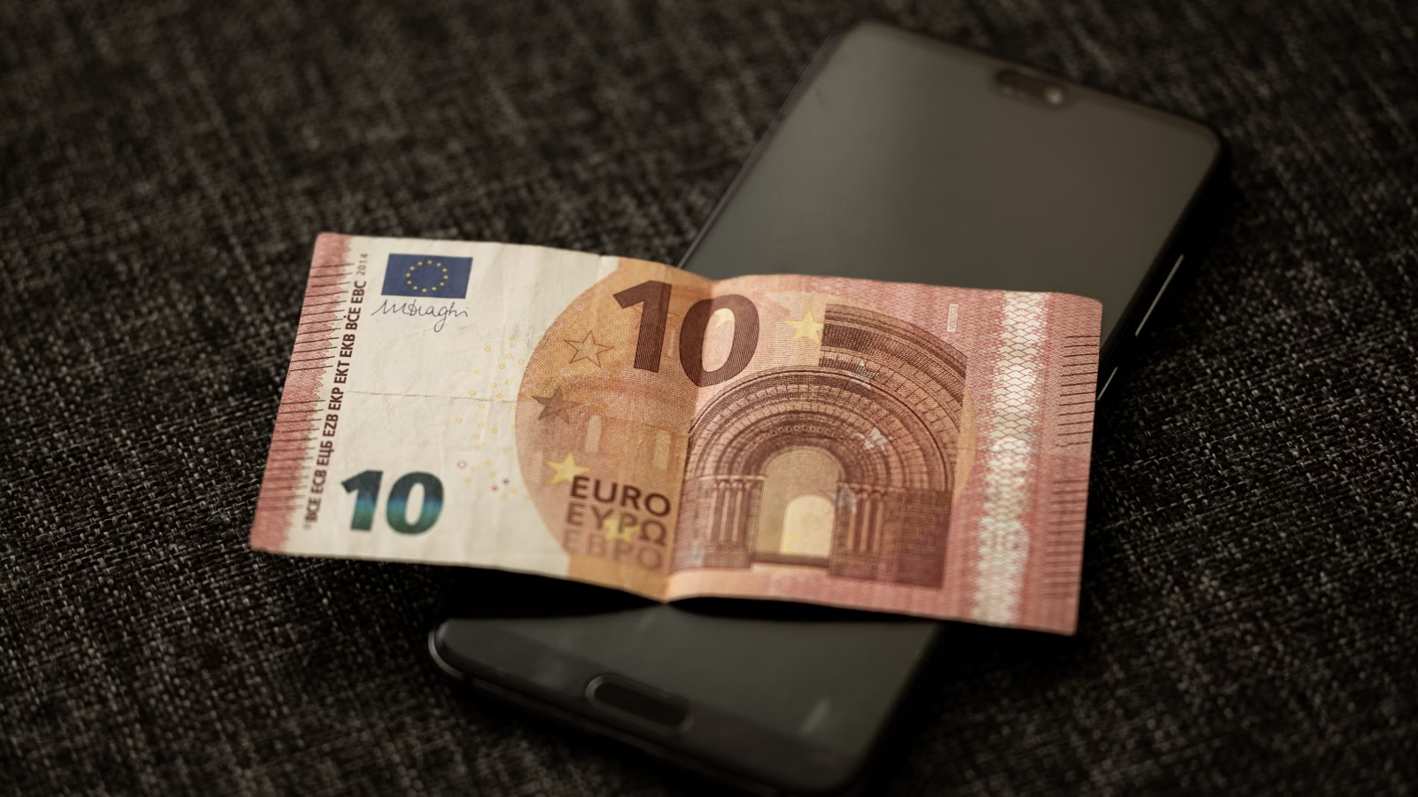 Money and smartphone representing a pending transfer