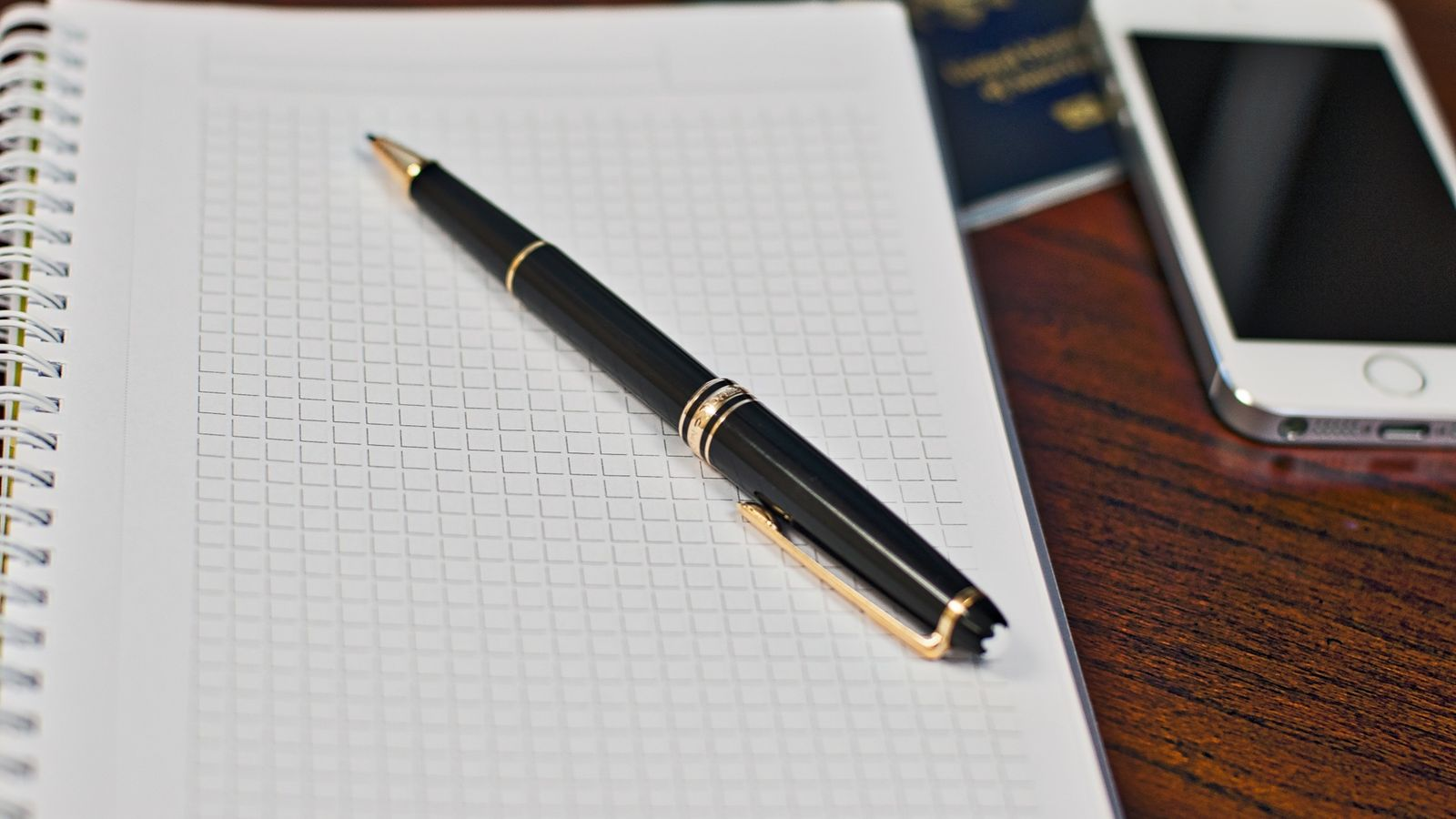 A passport, smartphone, and notebook representing identity and information preparation before a transfer