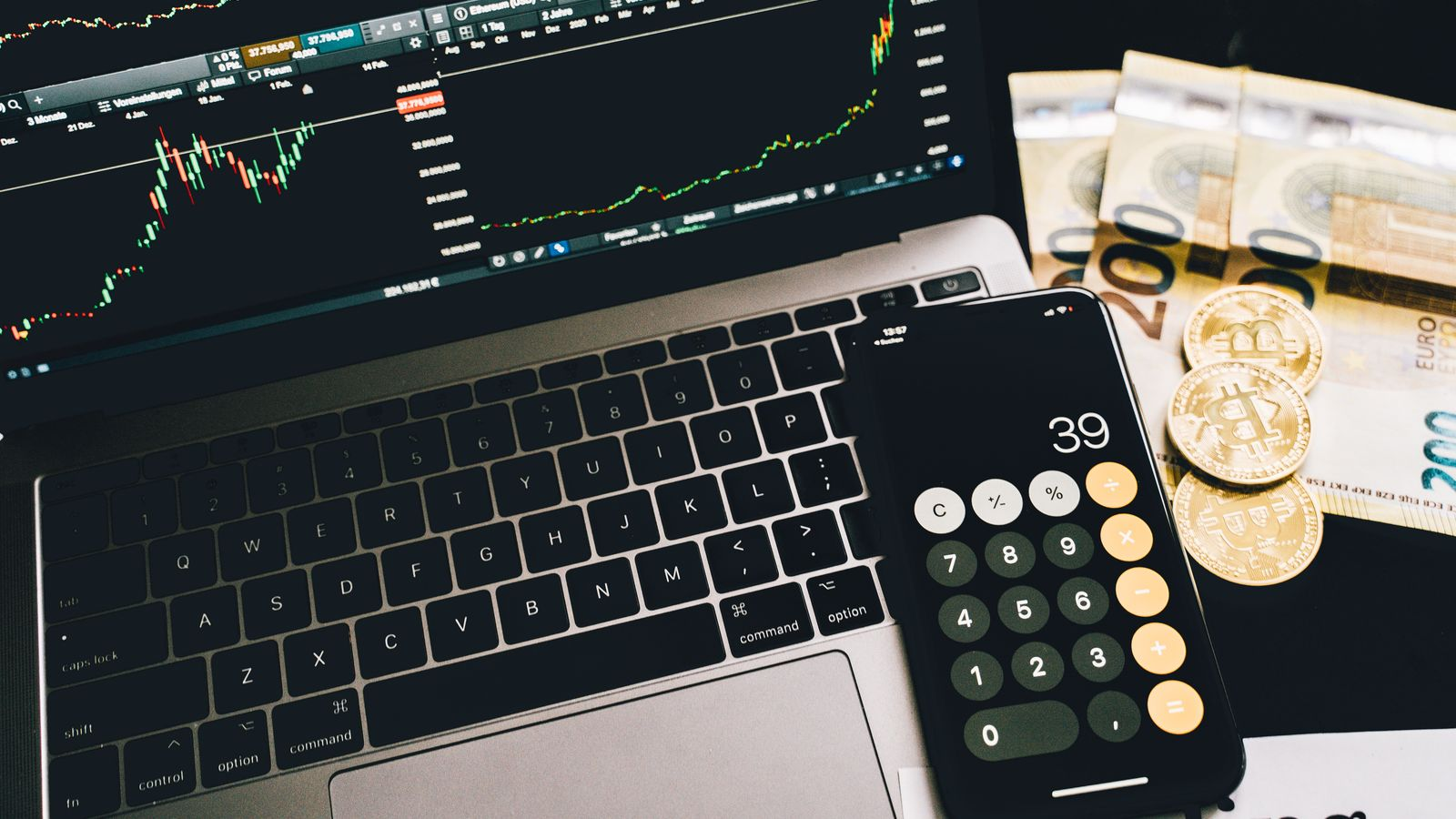 Market charts on a laptop alongside a calculator and crypto props, illustrating strategy and capital allocation analysis
