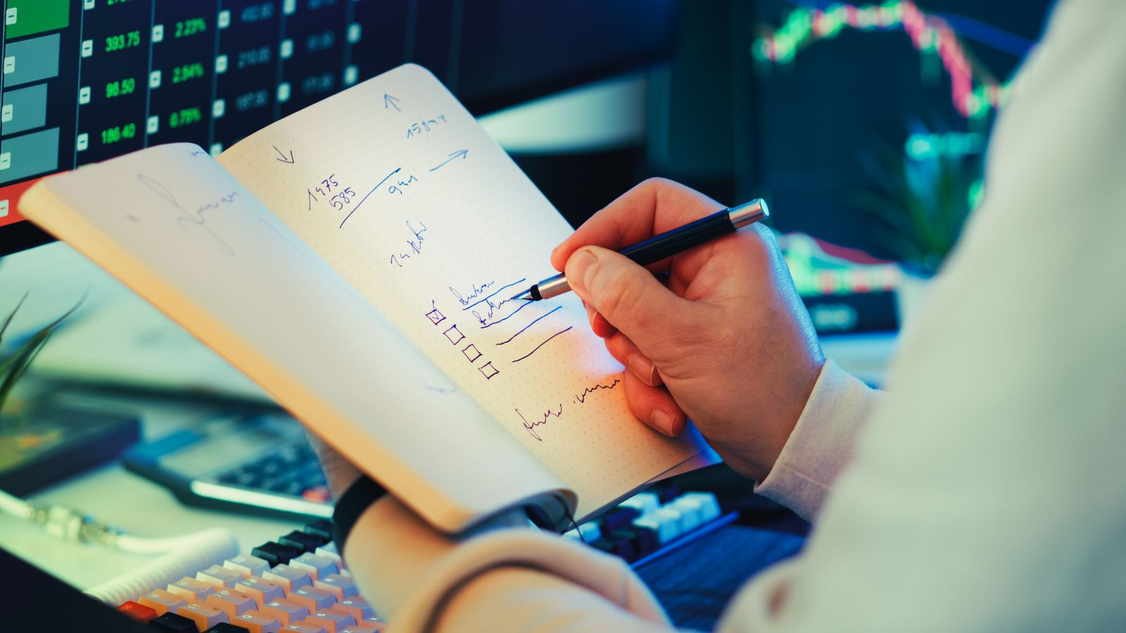 A user records market movements and checklist items in front of trading screens, illustrating planning and review