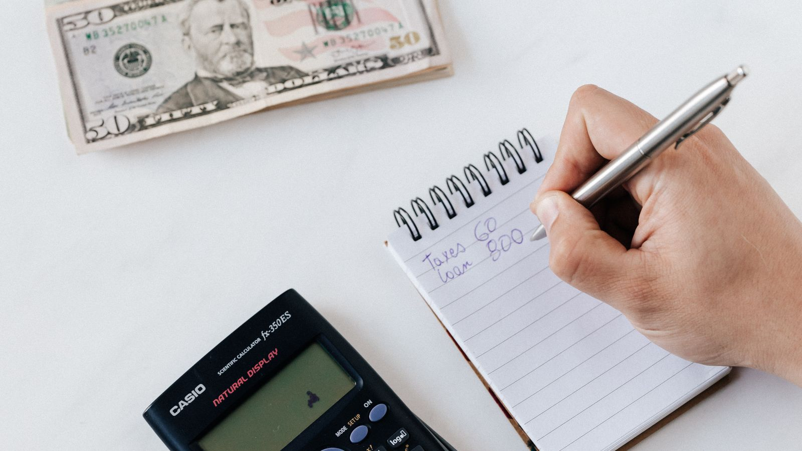 A calculator and notebook used to check fees and amounts