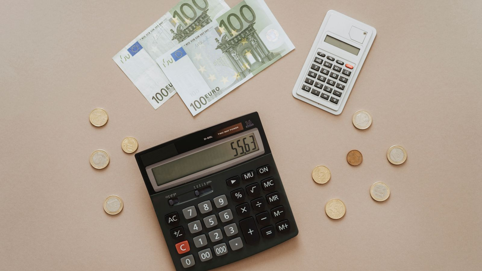 Calculators, euro banknotes, and coins used to work out a cross-border payment budget