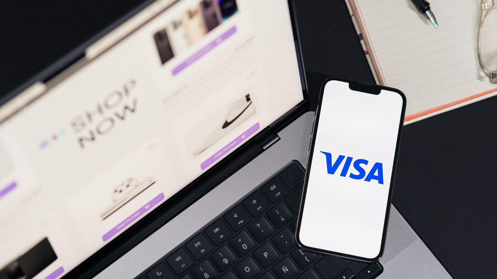 A phone displaying the Visa logo beside an online shopping screen, illustrating an online card payment scenario